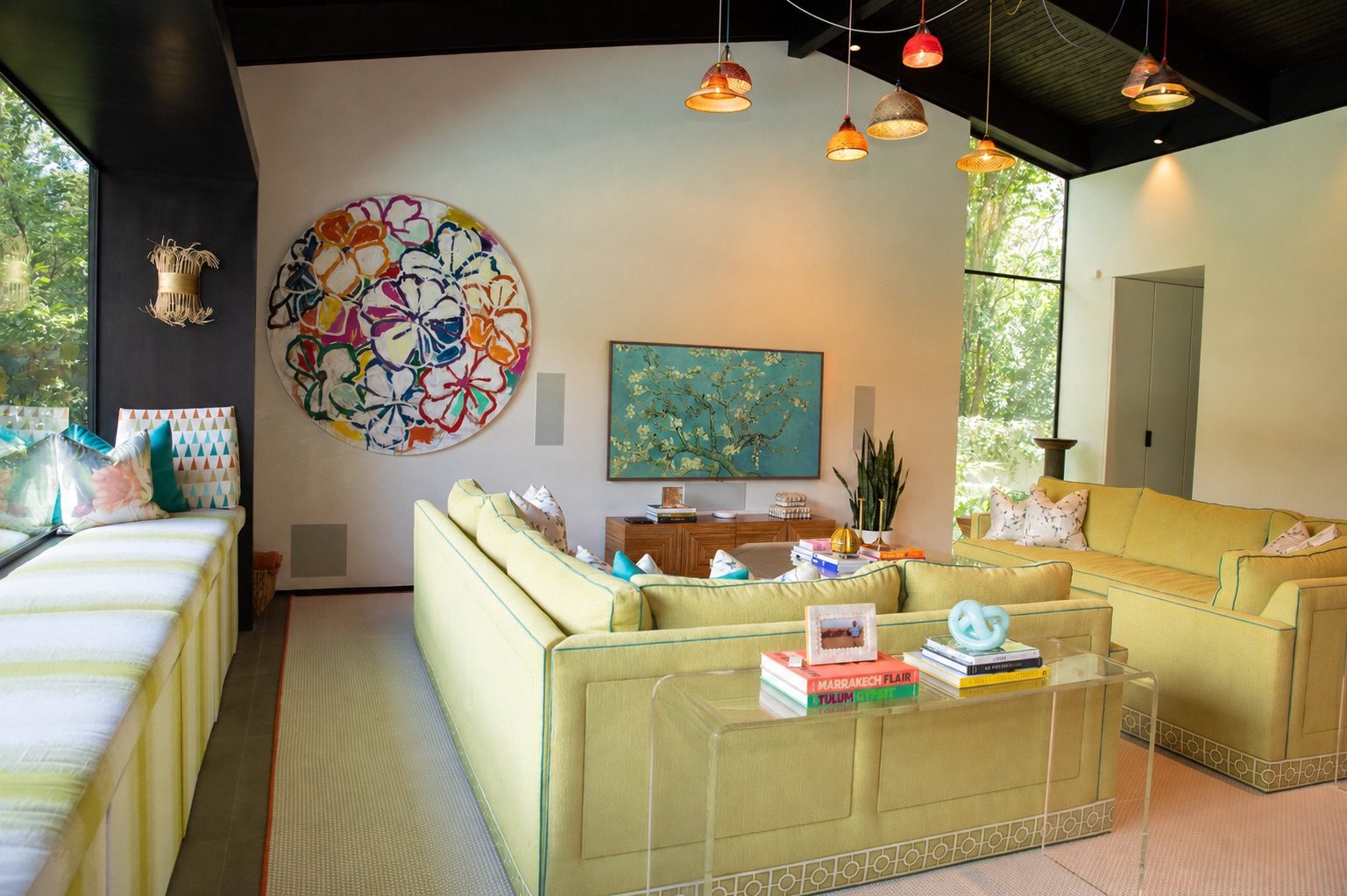 Family room with wall mounted television, concealed equipment, and colorful art in a River Oaks home by Media Systems