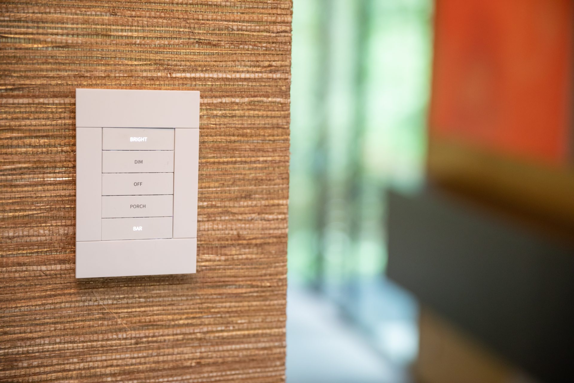 Engraved Crestron keypad on a grasscloth wall in a River Oaks smart home by Media Systems
