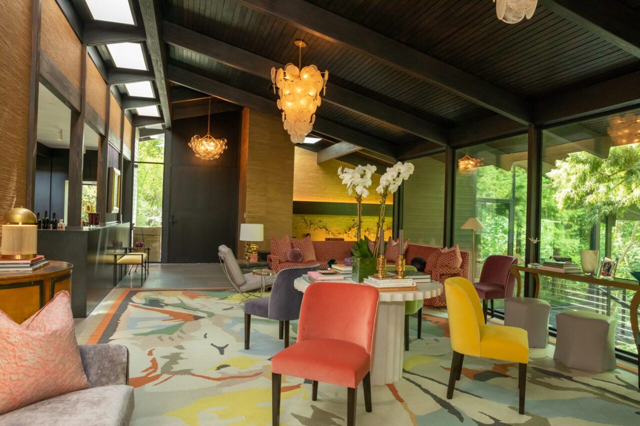 Living and dining room with colorful chairs and integrated technology by Media Systems