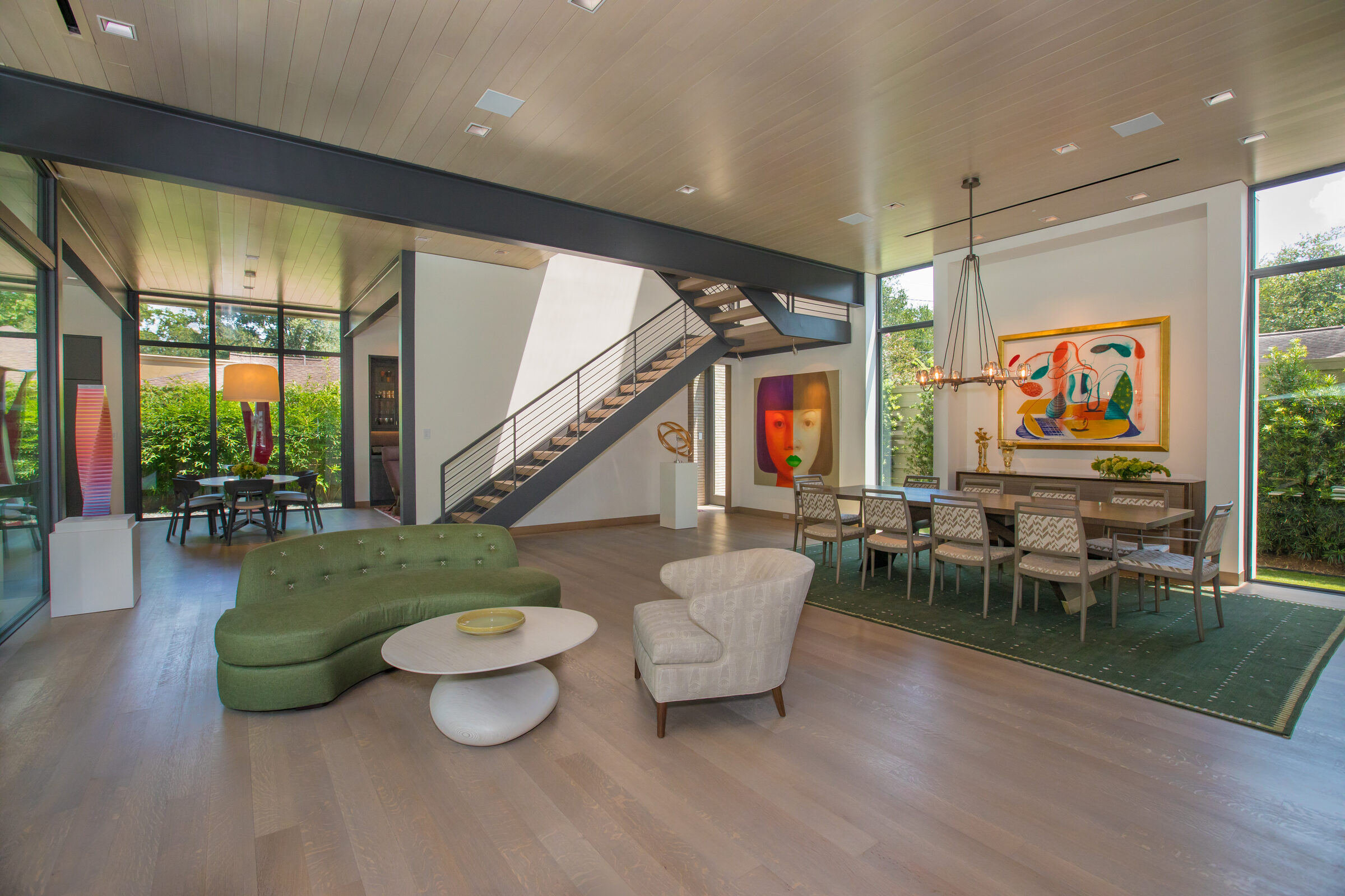 Two story great room with a staircase and floor to ceiling glass on both sides