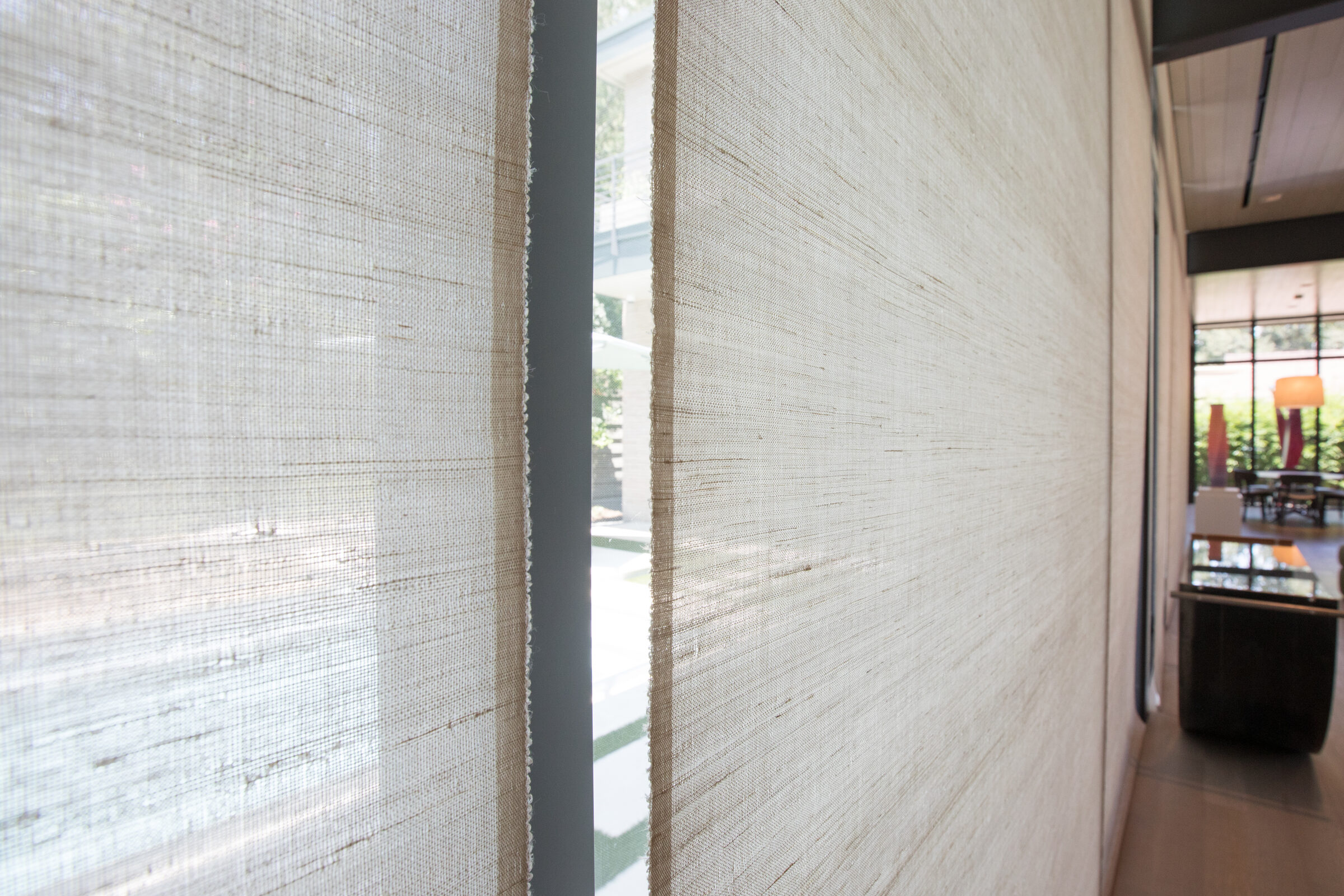 Close up of motorized shade fabric with the pool visible through the glass