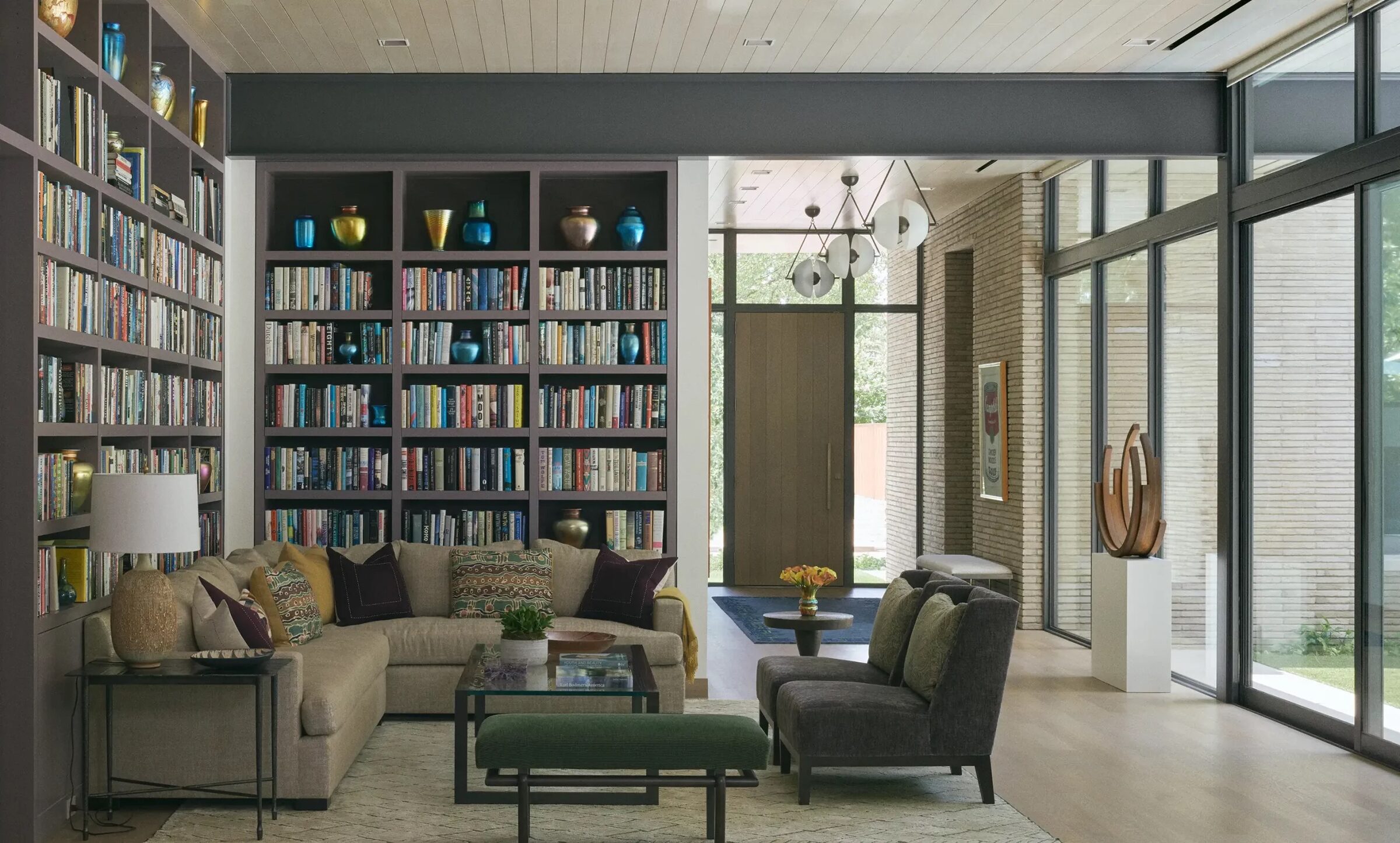 Living area with floor to ceiling built in shelving near the entry