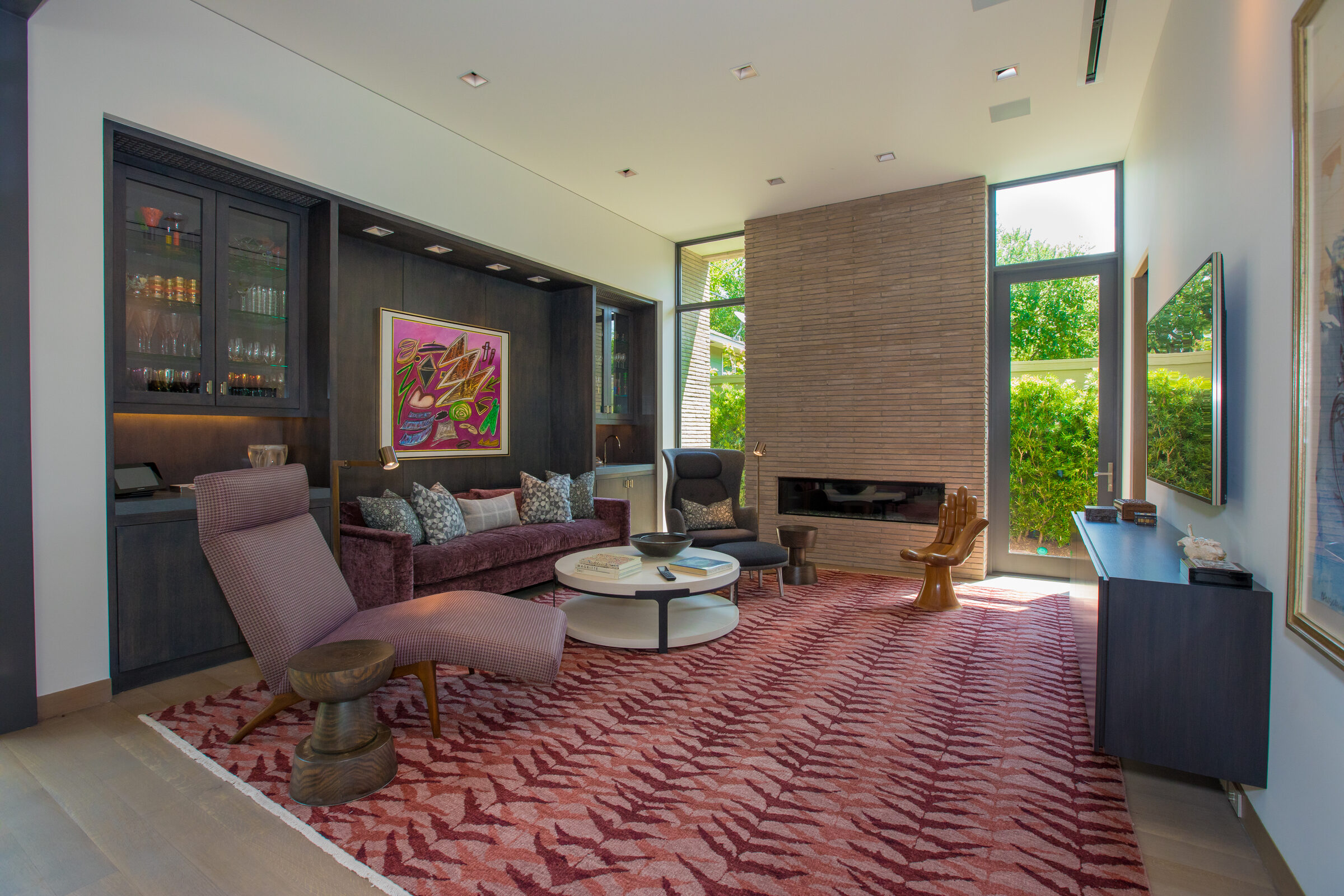 Den with a stone fireplace and a wall mounted television